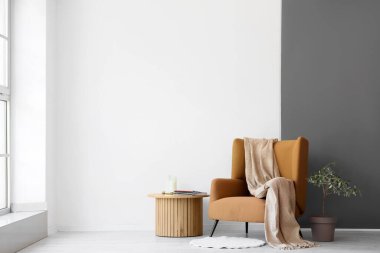 Kahve masasının yanında ekoseli rahat koltuk ve oturma odasında bitki.