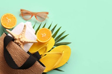 Renkli arka planda şık plaj aksesuarları, palmiye yaprağı ve portakalı kompozisyon