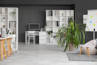 Koltuğu, işyeri ve raf ünitesi olan şık bir ofis.