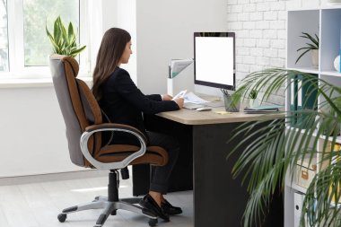 İş yerinde modern bilgisayar kullanan kadın ofis çalışanı.