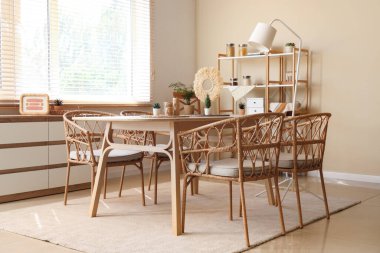 Ahşap masası ve raf ünitesi olan rahat bir yemek odası.