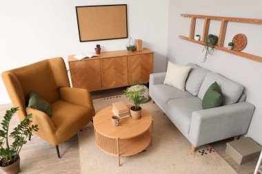 Açık oturma odası, kahverengi koltuk, rahat kanepe, sehpa ve çekmeceler.