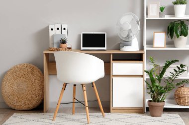 İş yerindeki bilgisayarlı elektrikli vantilatör.