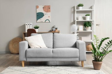 Evdeki kanepede elektrikli vantilatör.