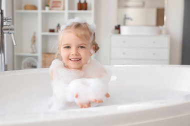 Köpüklü şirin kız banyoda banyo yapıyor.