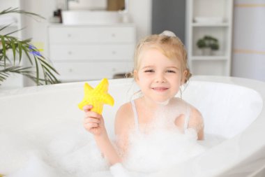 Oyuncak banyosu olan sevimli küçük bir kız.