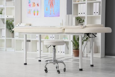 Tıp bürosunda dışkısı olan masaj koltuğu.