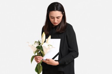 Nilüfer çiçeği buketi ve beyaz arka planda fotoğraf çerçevesi olan genç bir kadın.