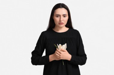 Beyaz arka planda zambak çiçeği olan genç bir kadın.