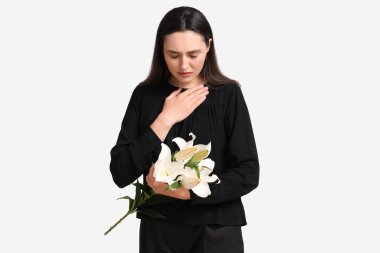 Beyaz arka planda zambak çiçekleri olan genç bir kadın.