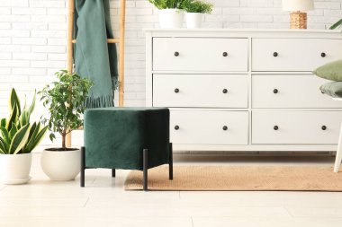 Pouf, çekmece sandığı ve oturma odasının içinde ekoseli merdiven.