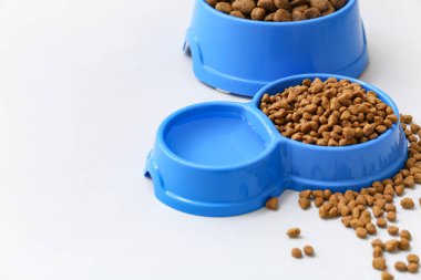 Beyaz arka planda kuru hayvan mamasıyla dolu kaseler