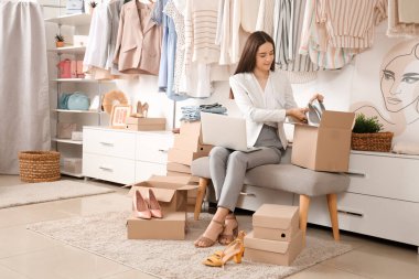 Kadın satıcı giysi mağazasındaki kutuya çevrimiçi ayakkabı siparişi vermiş.