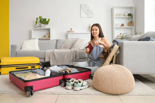 Dişi Asyalı gezgin, değerli eşyalarını evdeki ajandaya koyuyor.