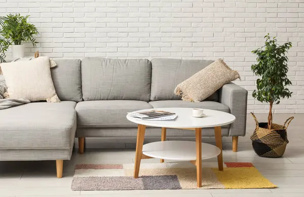 Rahat bir kanepe, kahve masası, dergi ve oturma odasında çay.