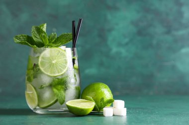 Yeşil arka planda taze mojito kokteyli ve nane şekeri.