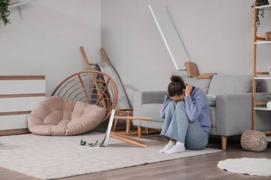 Deprem sırasında korkmuş genç bir kadın oturma odasında.