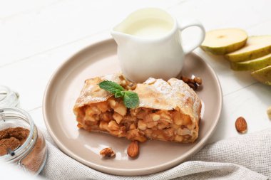 Lezzetli armutlu turta tabağı, beyaz ahşap arka planda taze meyve ve süt kes.