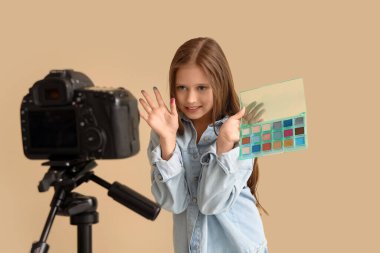 Bej arkaplan üzerine video kaydeden genç güzellik blogcusu