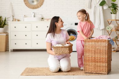 Genç anne, kızı ve sepeti evde.