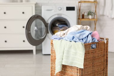 Çamaşır makinası ve kirli çamaşırlarla dolu sepet.