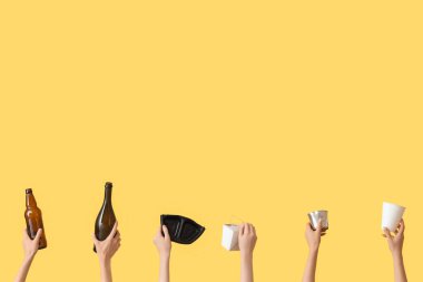 Sarı arka planda çöpleri olan kadın eller. Geri dönüşüm kavramı