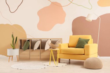 Rahat koltuk, lamba ve oturma odasının içinde yastıklar olan raf.