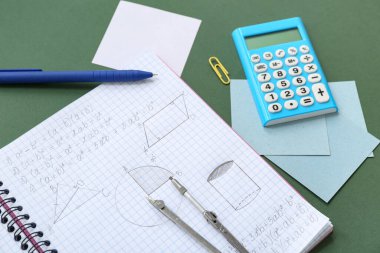 Tahtada hesap makinesi ve okul kırtasiyesi olan defter