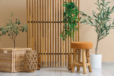 Konforlu koltuğu, çiçekleri ve ahşap perdesi olan şık bir oturma odası.