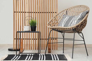 Rahat koltuğu, sehpası, lambası ve katlanır ekranı olan şık bir oturma odası.