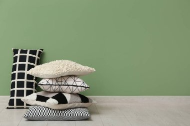 Yastıklar yeşil duvarın yanında, odada.