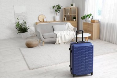 Oturma odasının iç tarafına mavi bavul konmuş.