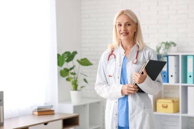 Klinikte defterleri olan kadın doktor.