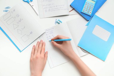 Fotokopi kitaplarıyla matematik formülleri yazan bir kadın.