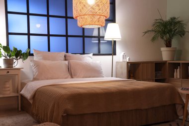 Yatak odasının içinde rahat bir yatak odası ve parlak lambalar var.