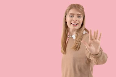 Genç iş kadını pembe arka planda sanal ekran kullanıyor