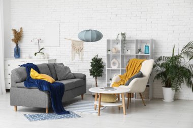 Yumuşak kanepesi, koltuğu ve sehpası olan bir oturma odası.