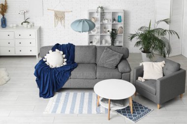 Yumuşak kanepesi, koltuğu ve sehpası olan şık bir oturma odası.