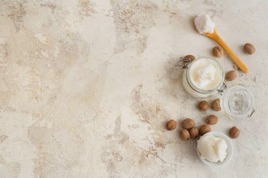 Cam kavanoz, arkaplanda tereyağı ve fındık var.