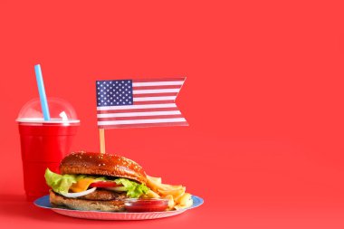 Amerikan bayrağı, patates kızartması ve kola arkaplanlı lezzetli bir burger. Amerikan Bağımsızlık Günü kutlamaları