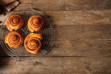 Tahta arka planda tatlı tarçınlı rulolarla dur