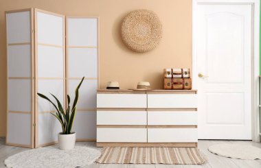 Koridorda şapka ve bavullu çekmeceler var.