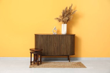 Klozette otlu vazo ve oda duvarının yanındaki masa.