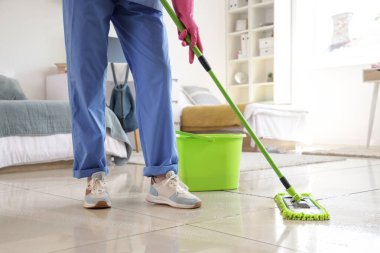 Yurt odasındaki yerleri paspaslayan hademe, yakın plan.