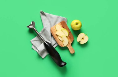 Blender, peçete, ahşap tepsi ve yeşil arkaplanda elmalar