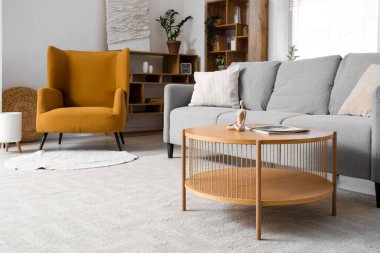 Gri kanepesi, koltuğu ve penceresi olan oturma odası.