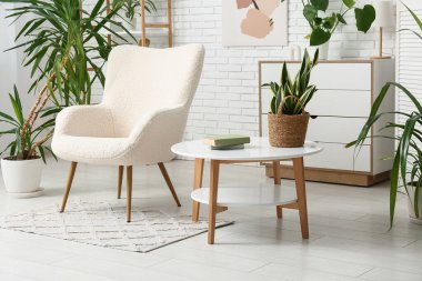 Oturma odasının iç tarafında kitap ve çiçeklerle dolu bir masa.