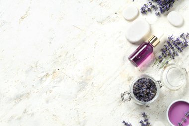 Hafif grunge arka planda spa taşları, şişe ve bir kase lavanta yağı.