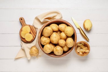 Beyaz ahşap arka planda çiğ patatesli tabak ve yemek.