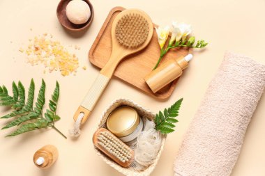 Renkli arkaplanda spa aksesuarları, kozmetik ürünleri ve eğreltiotu yaprakları ile kompozisyon